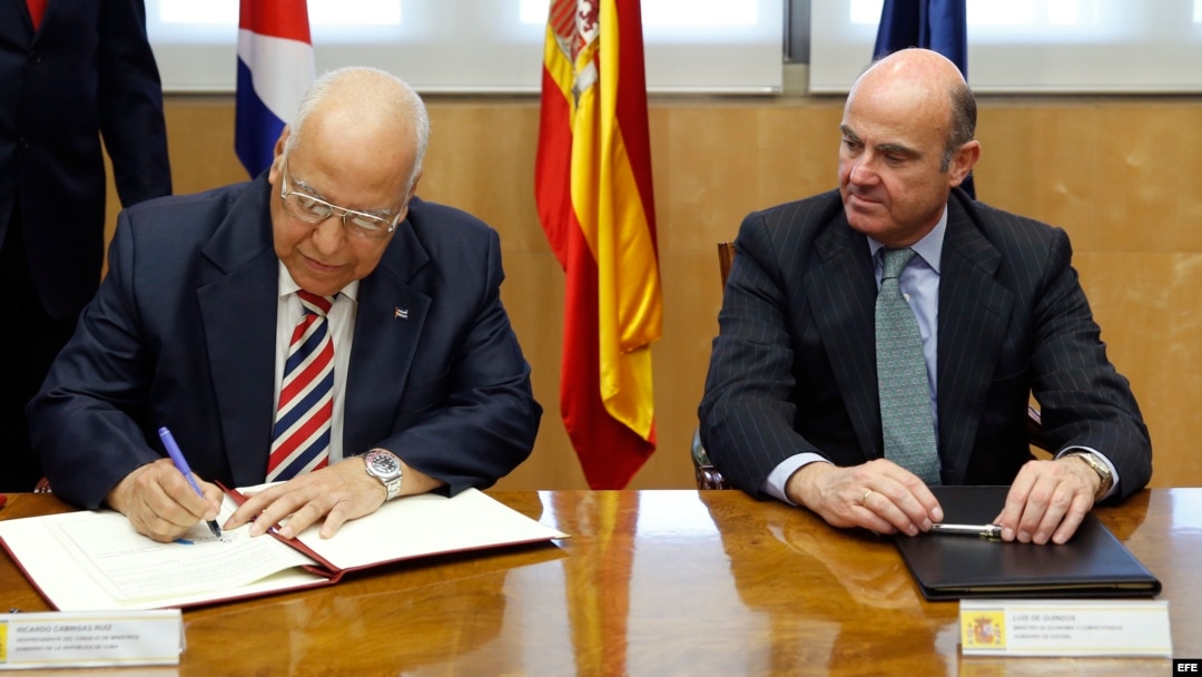 El ministro español de Economía y Competitividad en funciones, Luis de Guindos (d), y el vicepresidente del Consejo de Ministros de Cuba, Ricardo Cabrisas Ruiz (i), durante la firma de los acuerdos para reestructurar la deuda cubana con España. (Archivo)